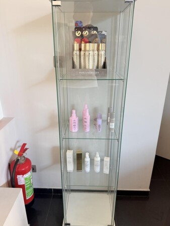 Une vitrine d'exposition verticale en verre avec tablettes.